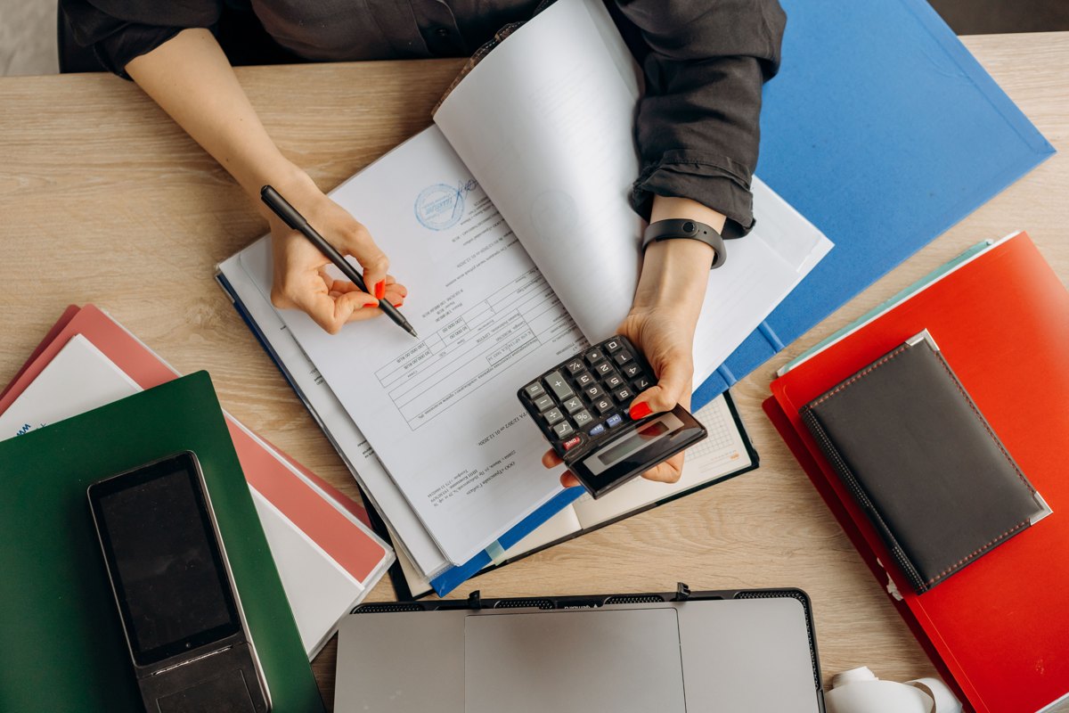 A person reviewing financial documents with a calculator